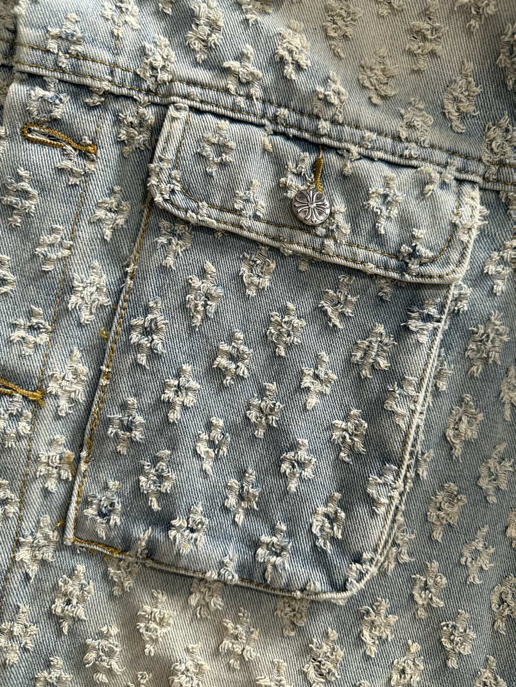 Denim jacket yoke and chest pocket with floral embroidery and stitched trim