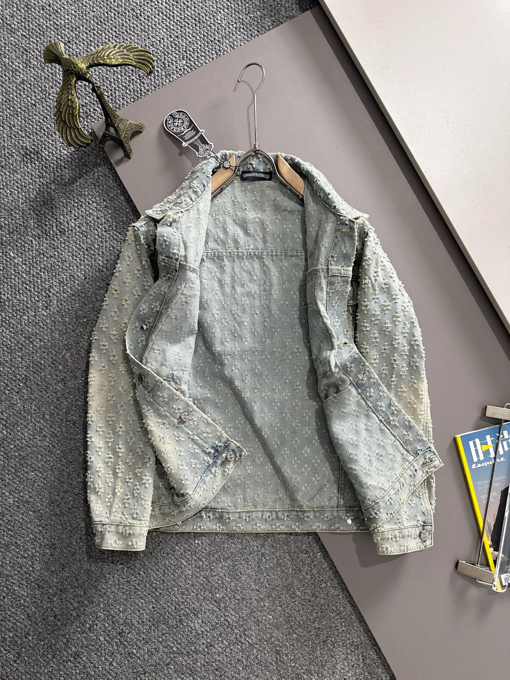 Light blue denim jacket on hanger with floral embroidery, button front, flap pockets