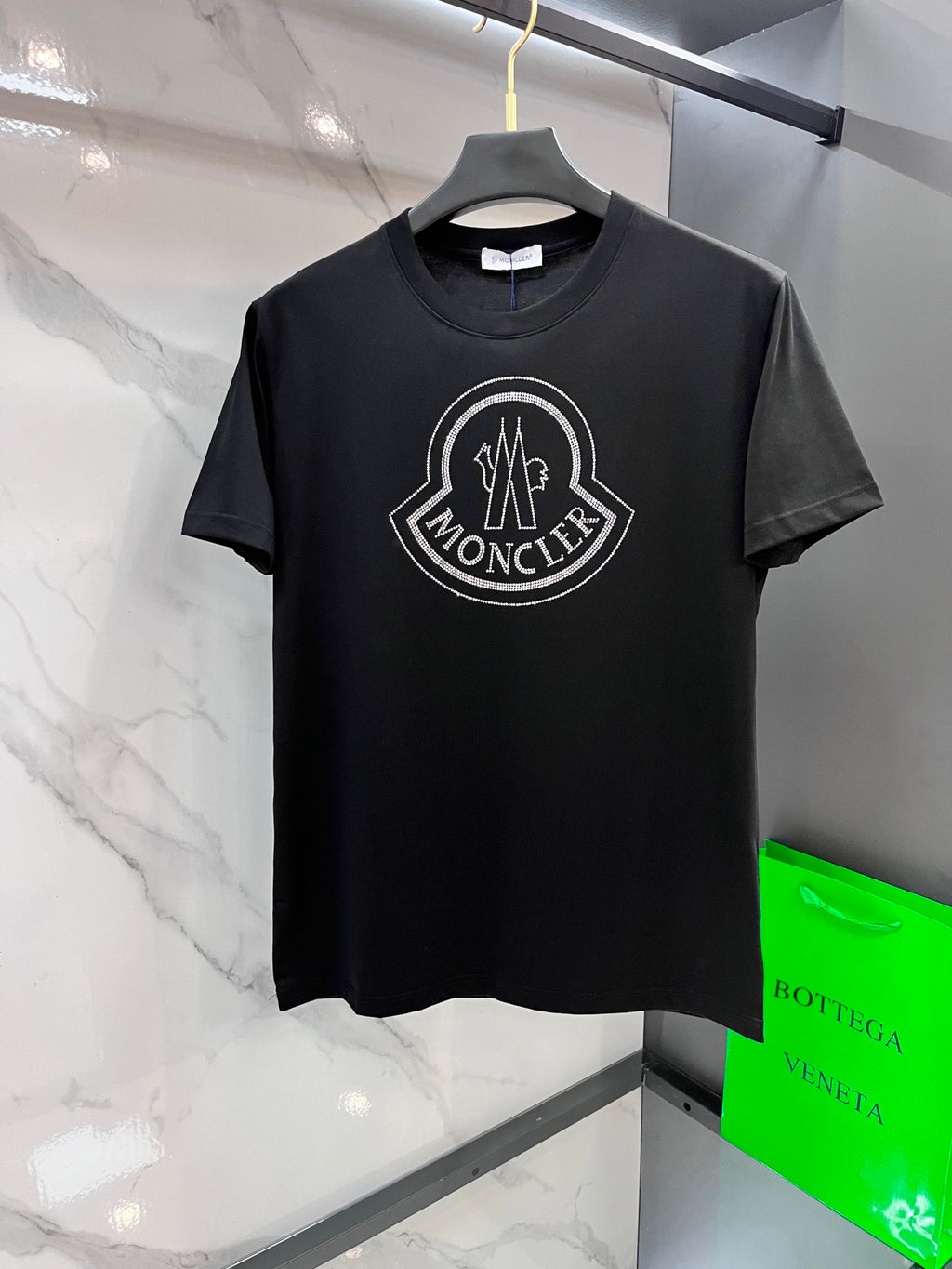 Black T-shirt with large rhinestone logo on the chest