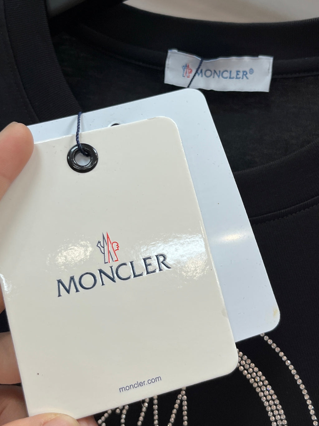 Black T-shirt with Moncler hang tag near the collar