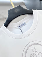 White Moncler T-shirt neckline with brand tag and rhinestone logo detail.