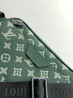 Louis Vuitton teal monogram fabric close-up with black strap detail