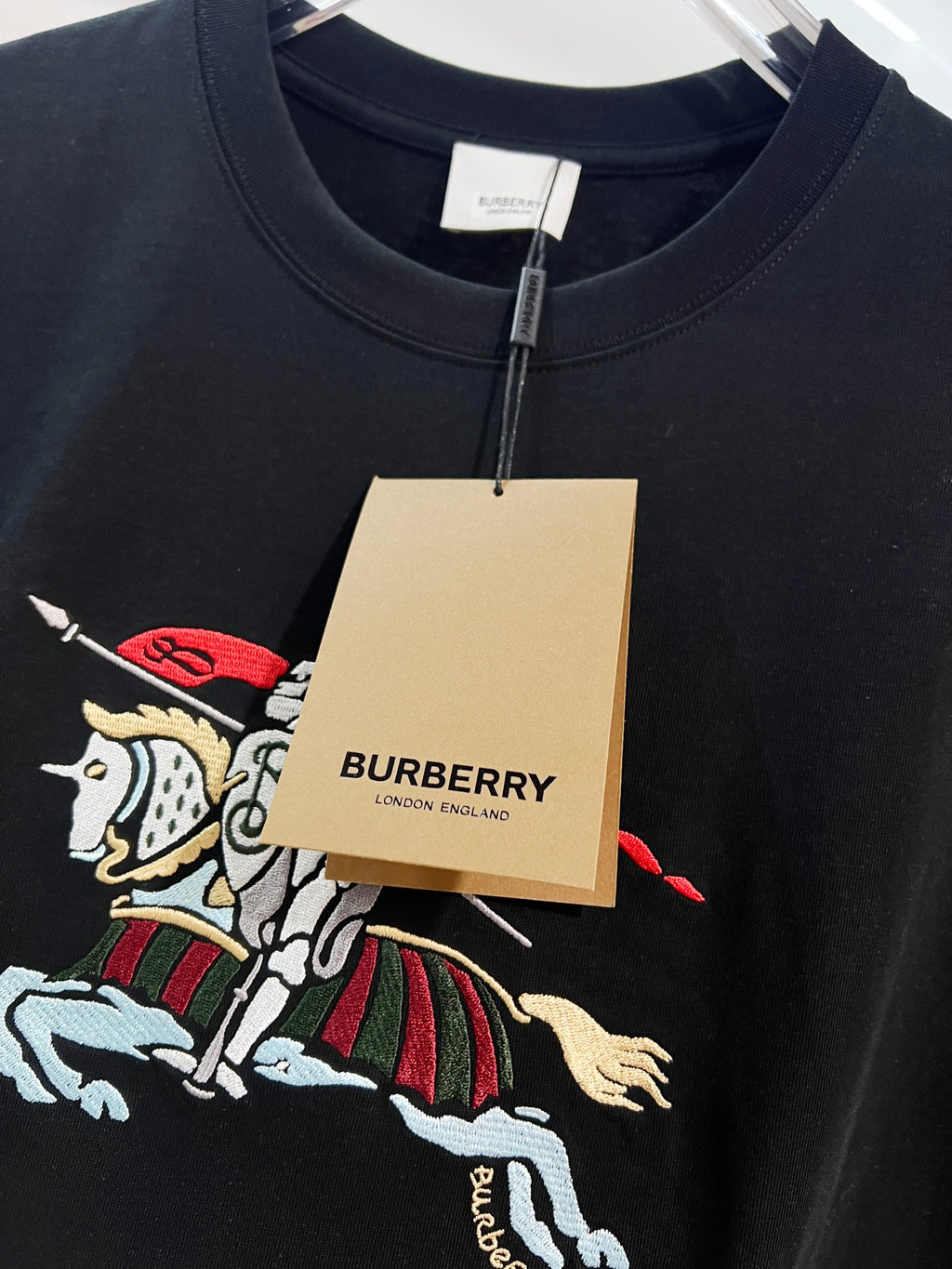 Black T-shirt with embroidered horse graphic and neck tag