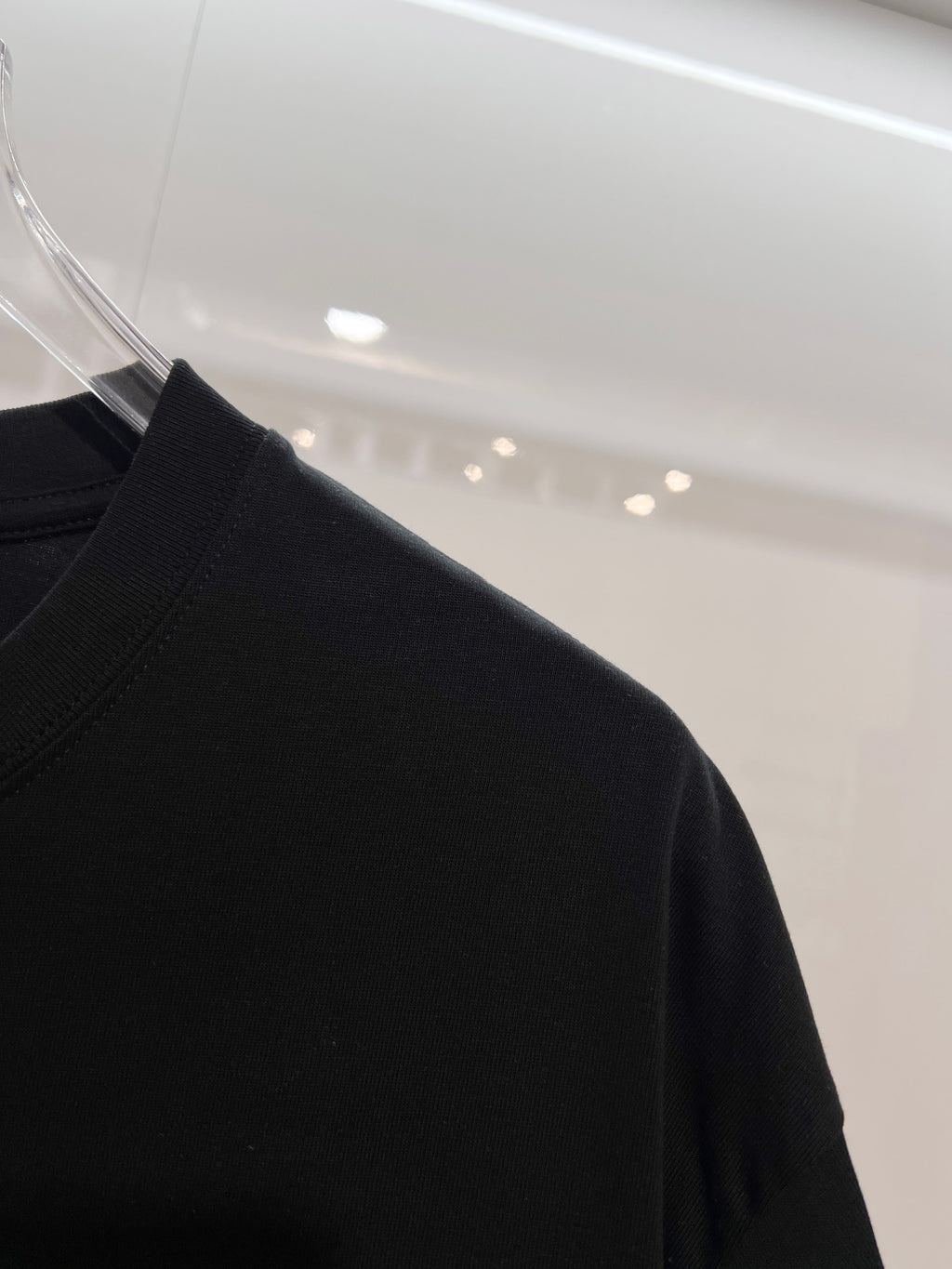 Black T-shirt shoulder and sleeve in side view