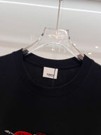 Black short-sleeve T-shirt neck and collar on clear hanger