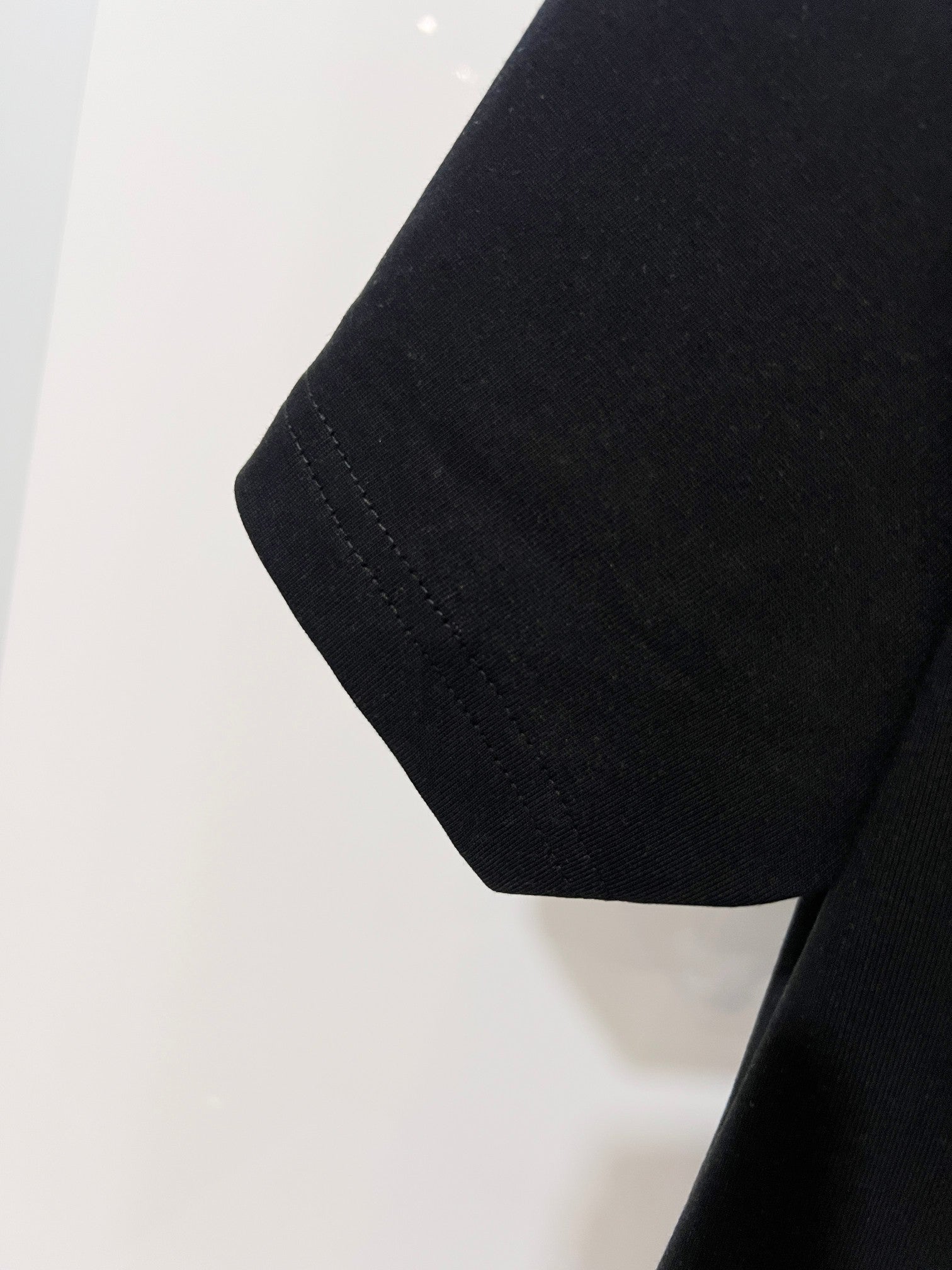 Black T-shirt hem and side seam detail
