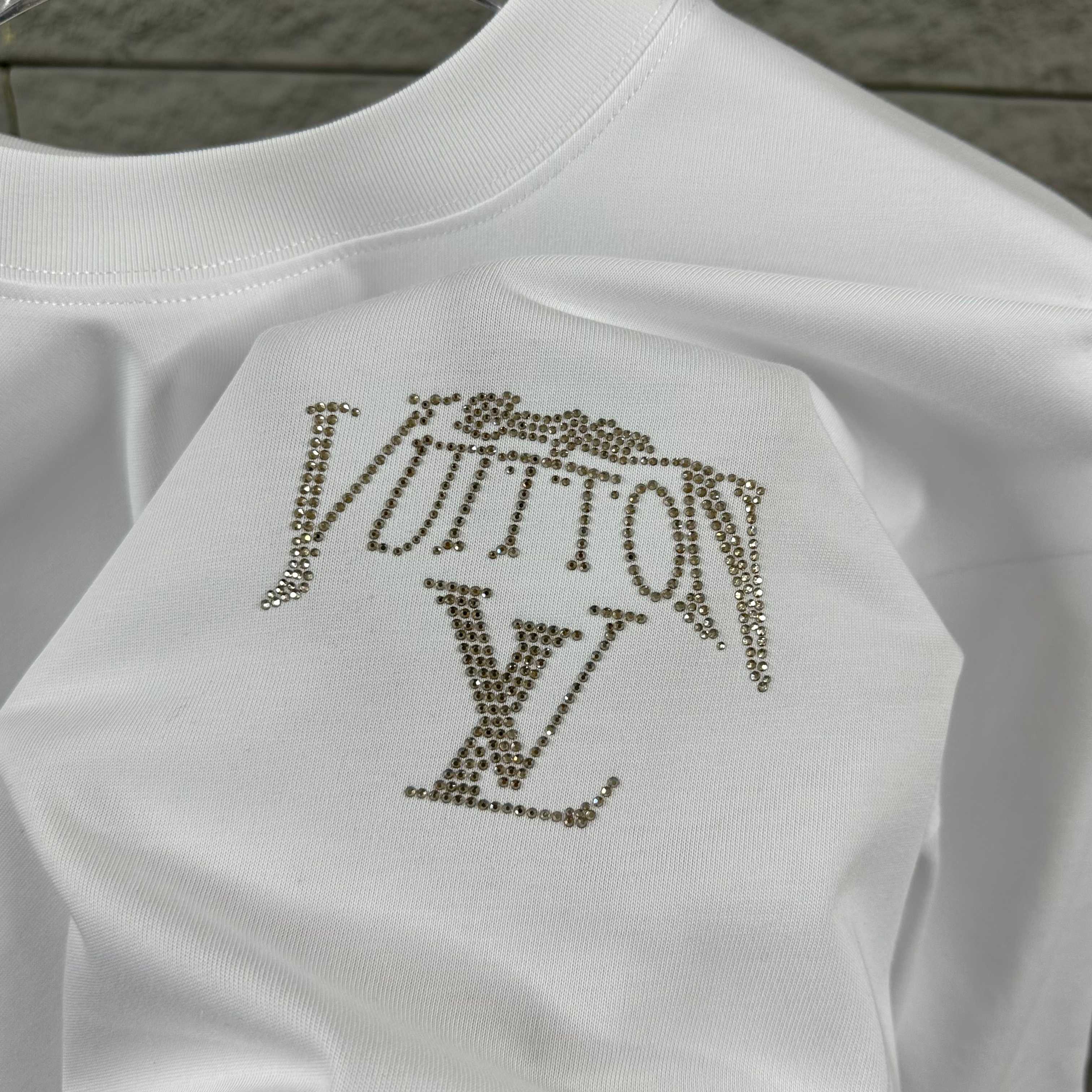 Close-up of white Louis Vuitton T-shirt with rhinestone LV logo on back