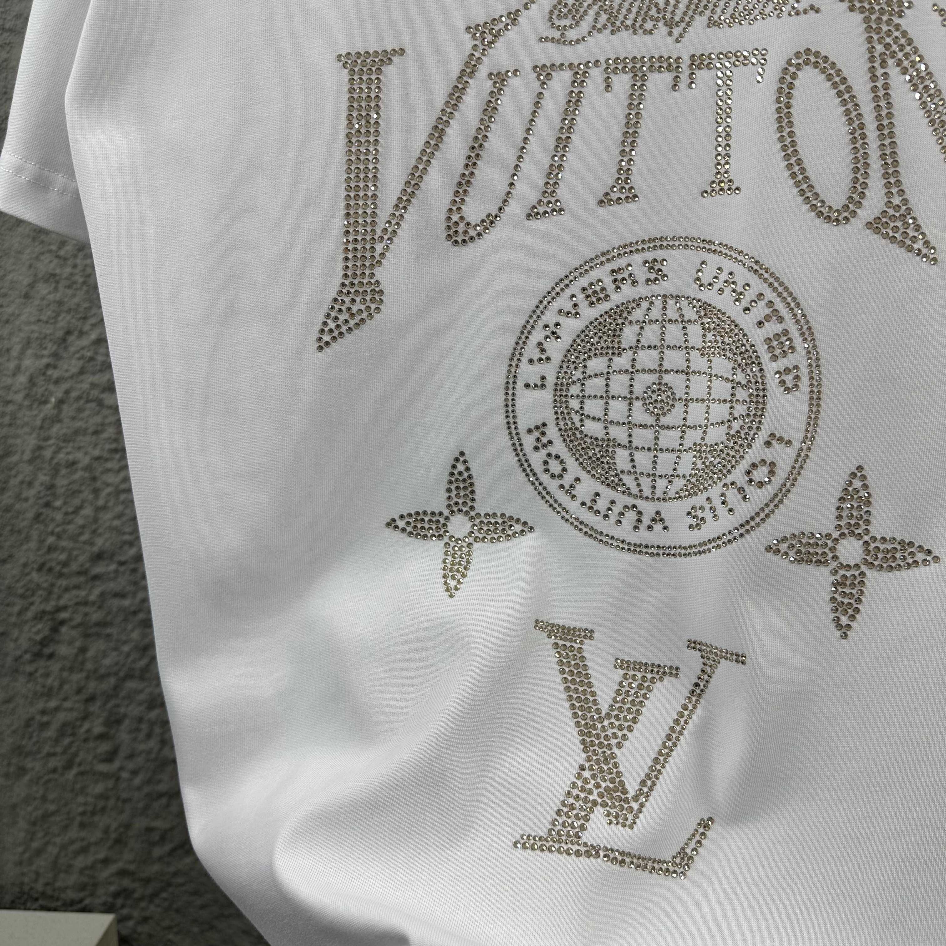 Close-up of white Louis Vuitton T-shirt rhinestone globe, stars, and LV lettering