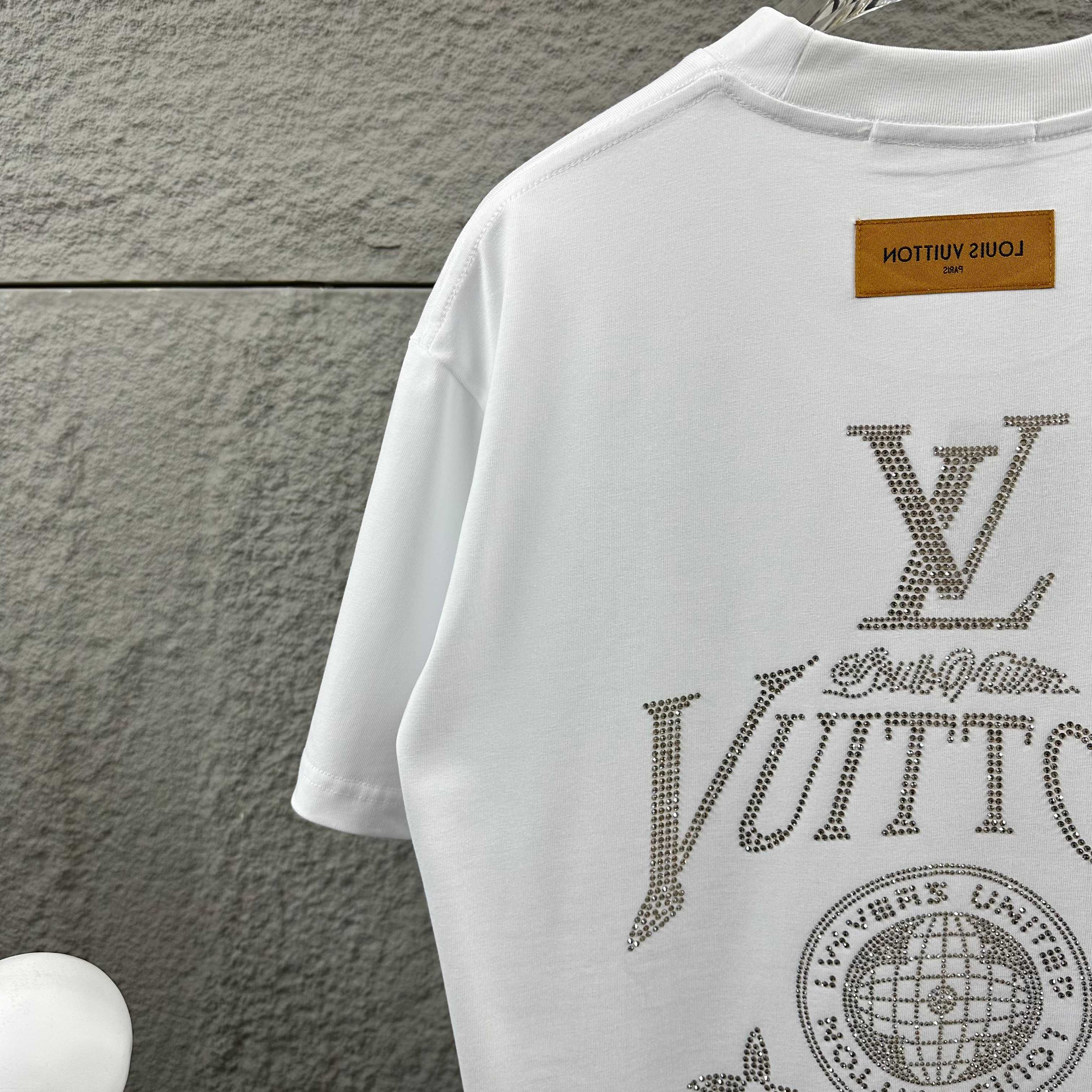 Back of white Louis Vuitton T-shirt with rhinestone LV and globe emblem detail