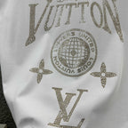 Close-up of white Louis Vuitton T-shirt rhinestone LV lettering and globe emblem