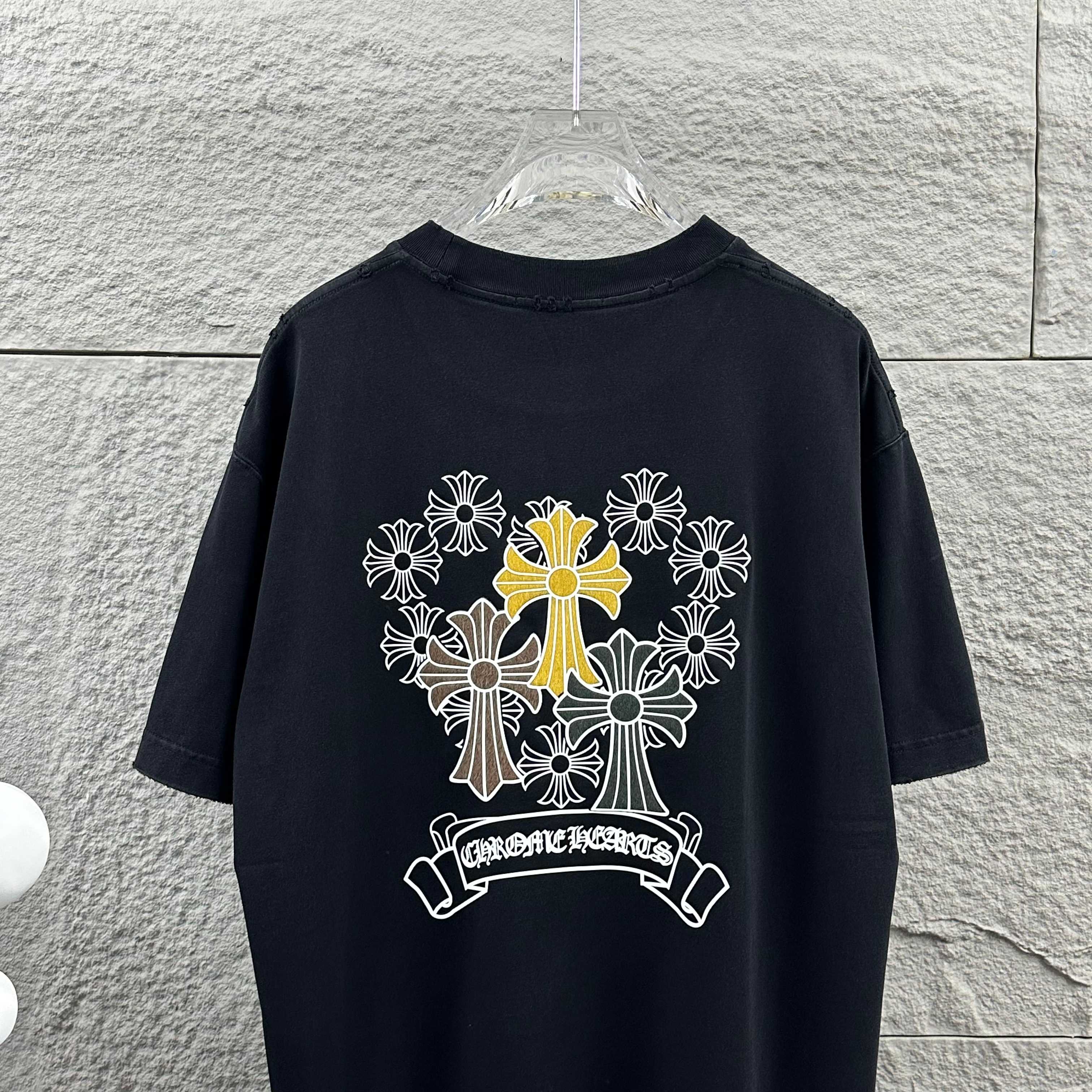Dark T-shirt showing large cross-flower graphic with ribbon banner