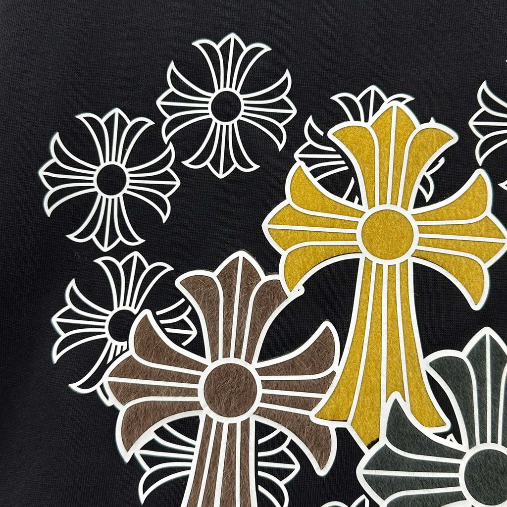 Dark T-shirt close-up of cross-flower graphic with golden center