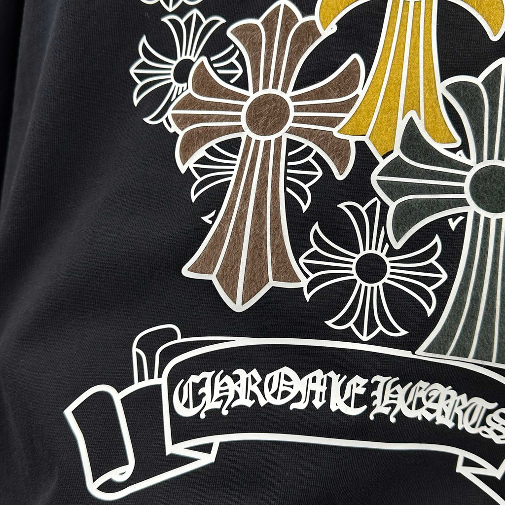 Dark T-shirt close-up of banner ribbon and cross-flower design