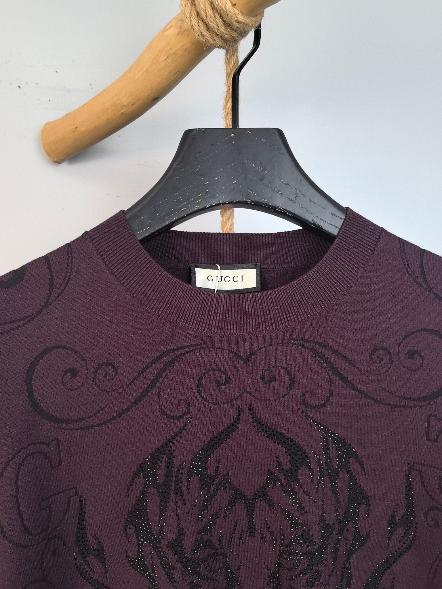 Gucci crewneck sweater neckline with Gucci label, dark plum and embroidered swirls