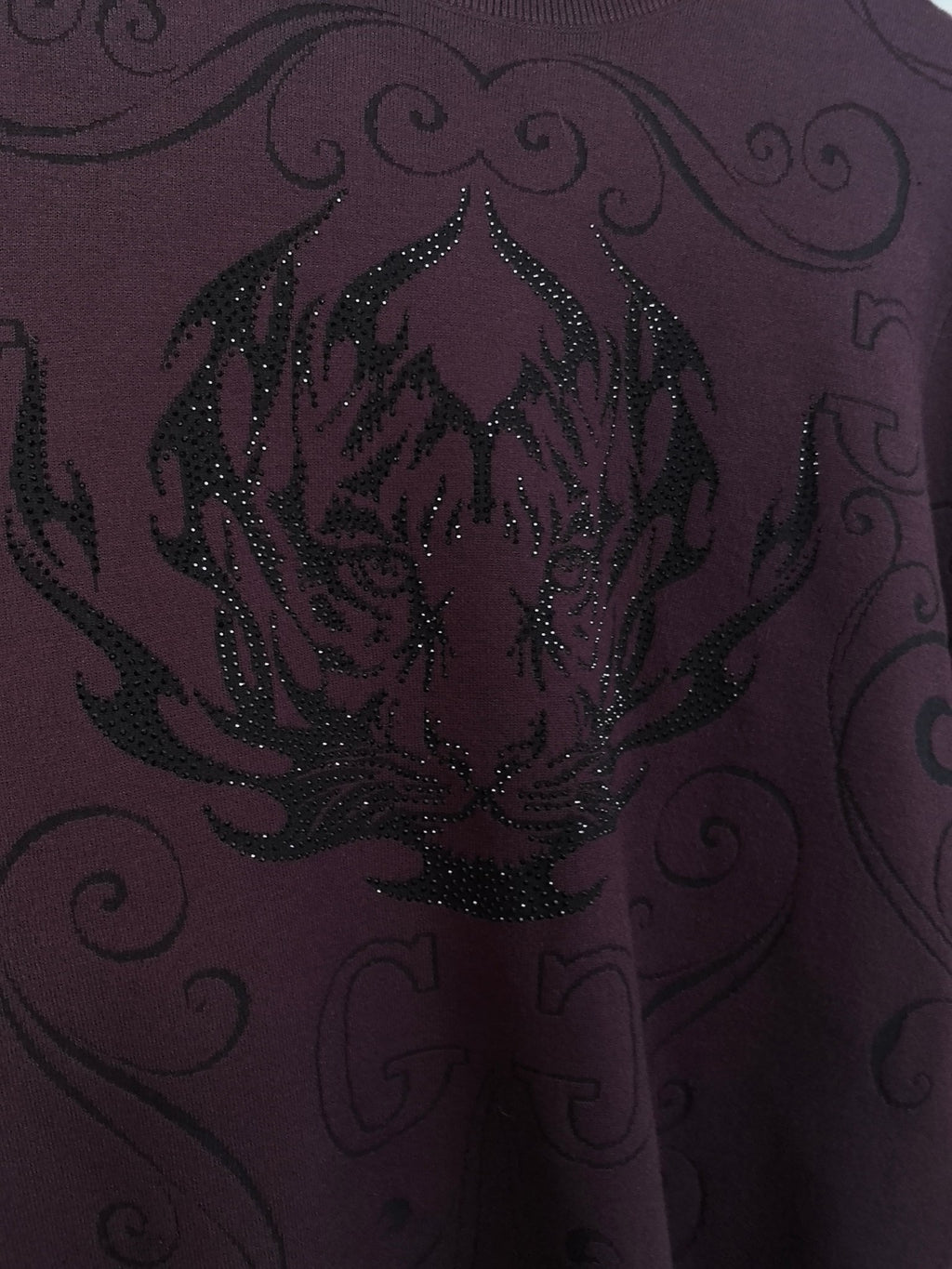Front graphic on dark plum crewneck sweater with glittering sequin texture and scrolls