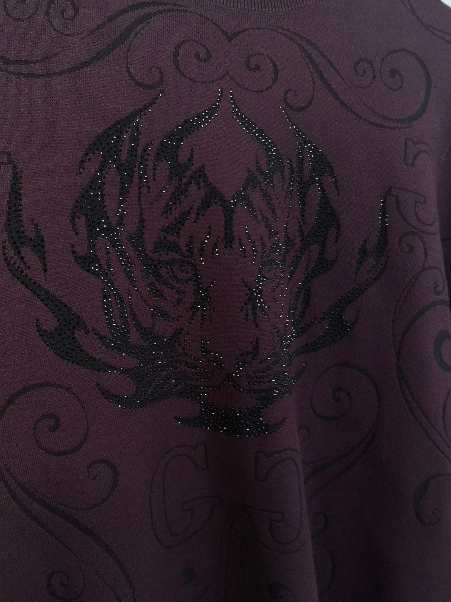 Front graphic on dark plum crewneck sweater with glittering sequin texture and scrolls