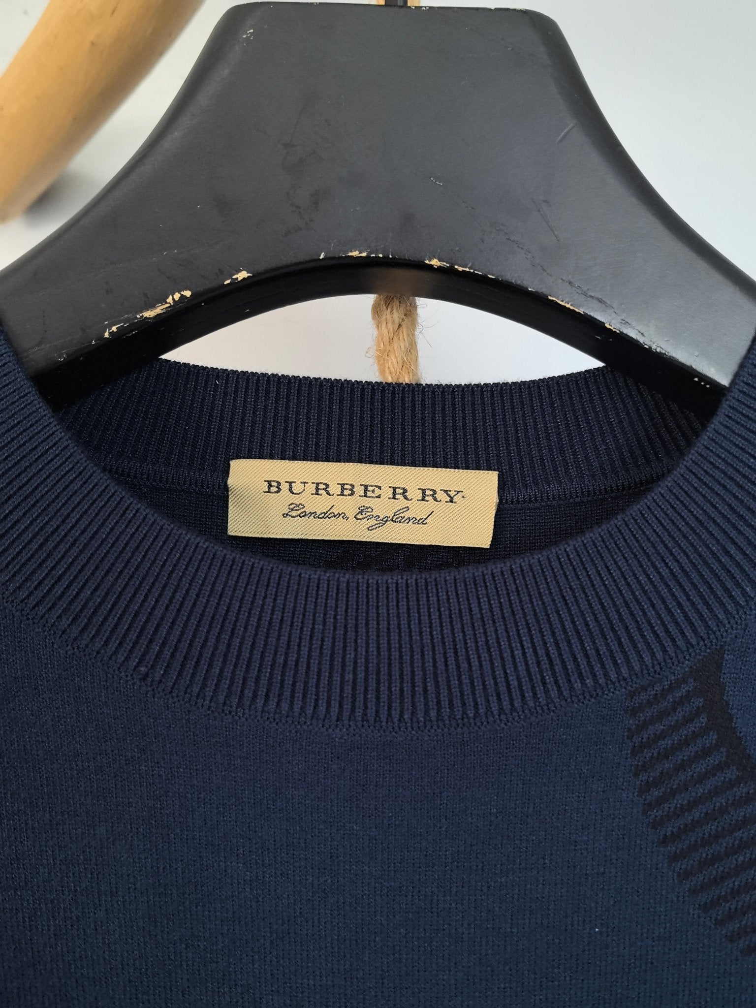 Burberry crew-neck sweater neckline with gold “BURBERRY” label and ribbed collar.