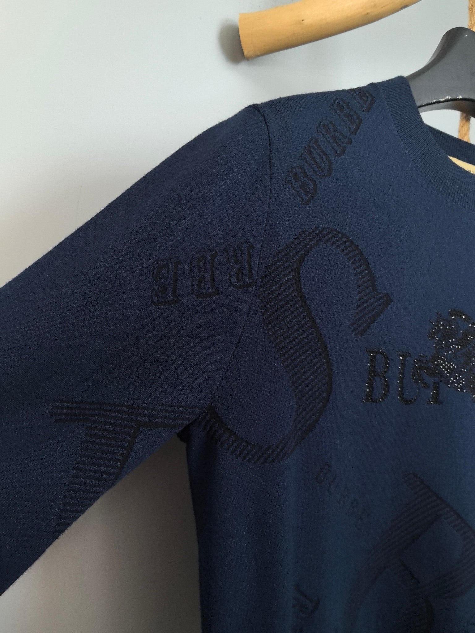 Burberry long-sleeve sweater side view with raised logo pattern on sleeve and body.