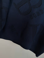 Burberry long-sleeve sweater close-up of allover ribbed logo pattern on fabric.