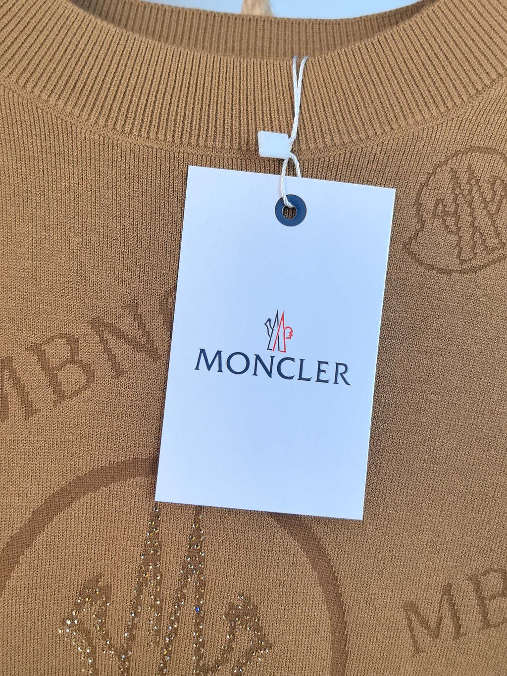 Moncler brand tag on tan knit sweater collar
