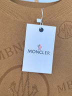 Moncler brand tag on tan knit sweater collar