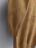 Tan knit sweater close-up of hem and allover Moncler logo pattern