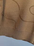 Tan Ralph Lauren sweater fabric close-up with allover graphic lettering and lines