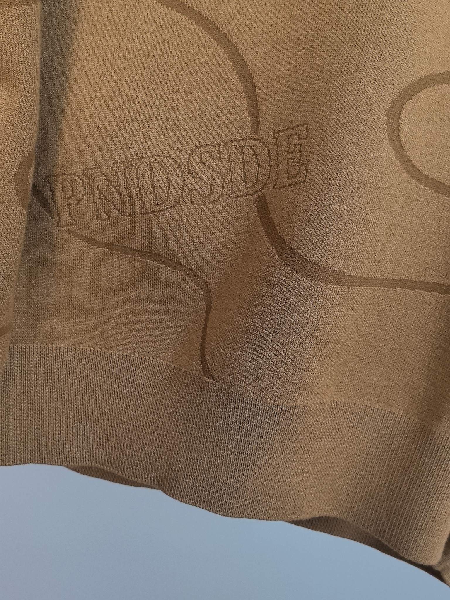 Tan Ralph Lauren sweater fabric close-up with allover graphic lettering and lines