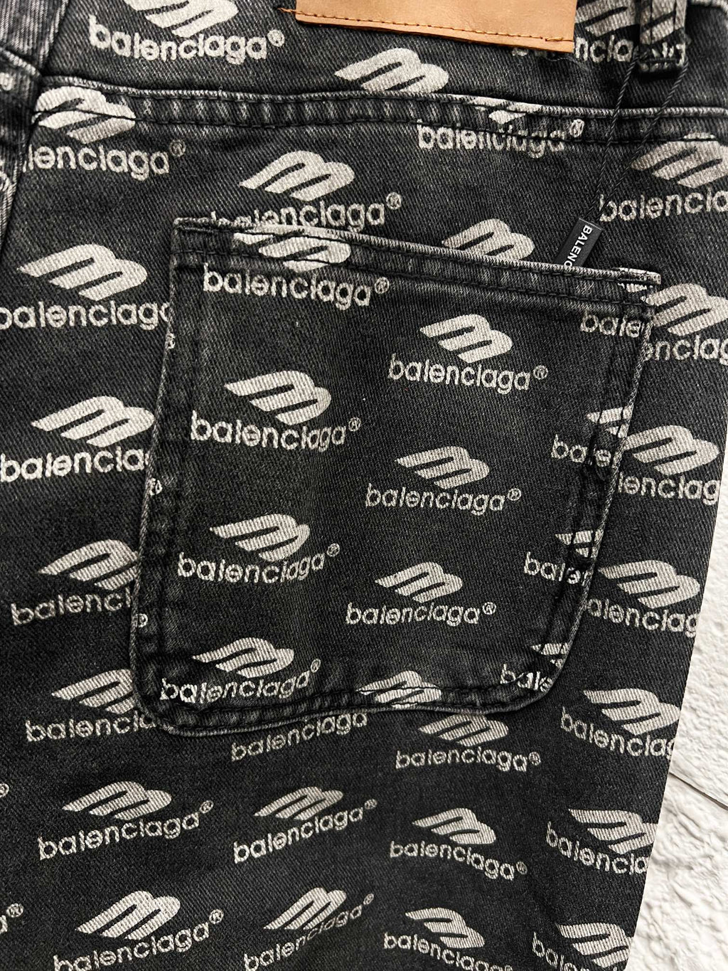 Balenciaga logo-print fabric on black denim pants, close-up