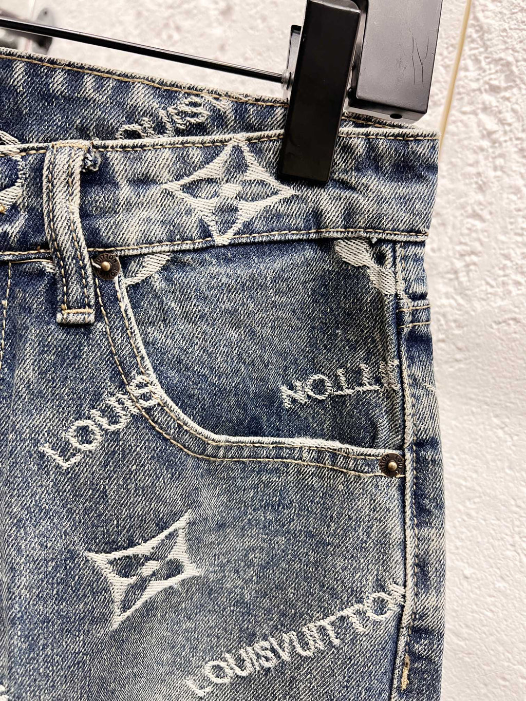 Front pocket area on light blue denim with white Louis Vuitton monogram print