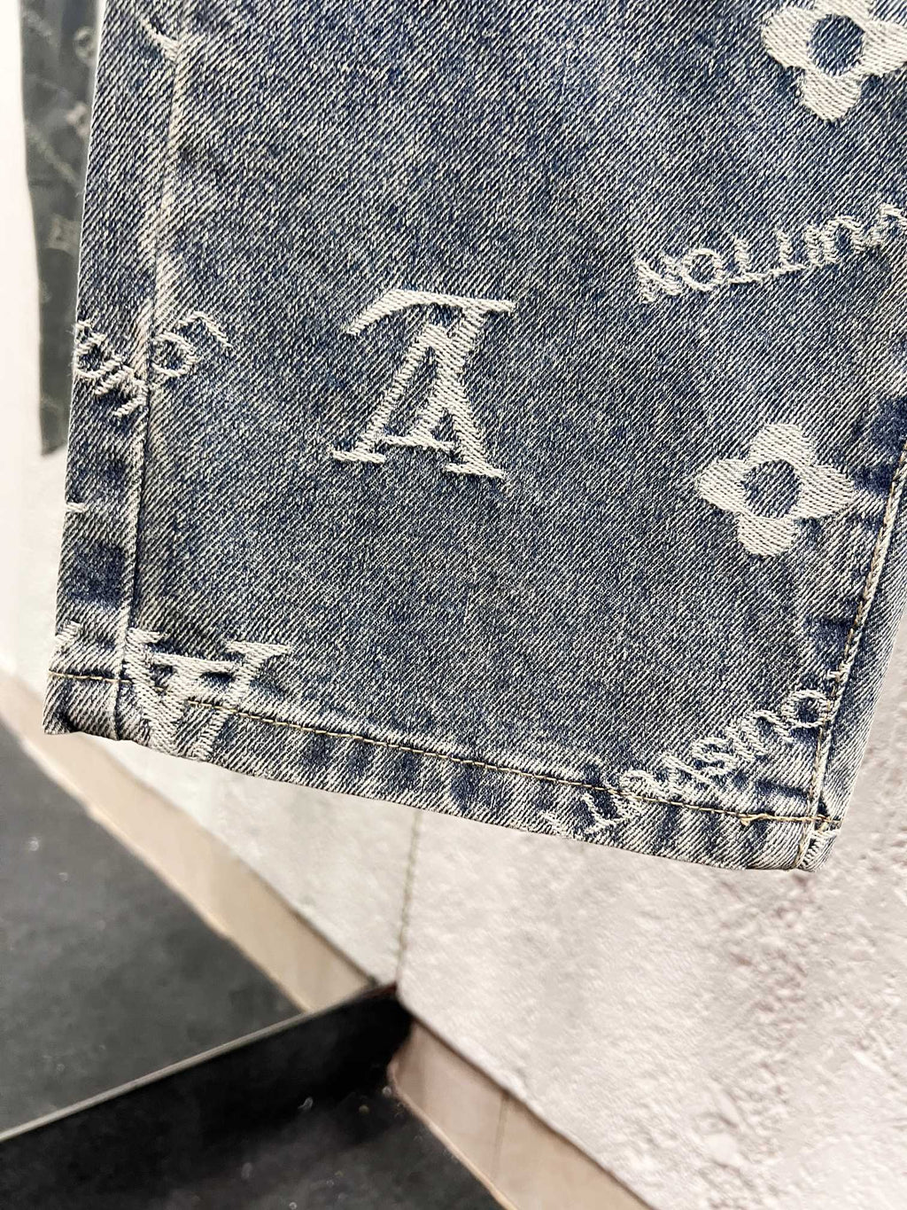 Denim pant hem with buttoned edge and white Louis Vuitton monogram motifs