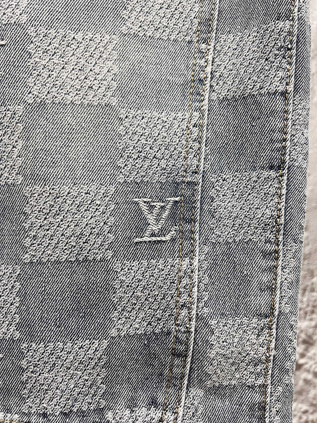 Louis Vuitton monogram denim close-up with stitched checker blocks and logo
