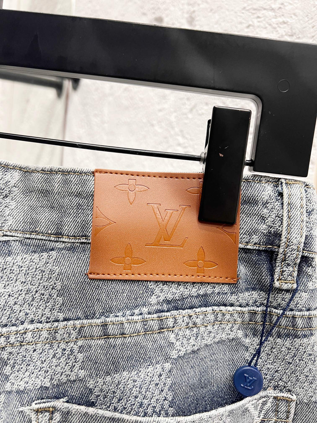 Louis Vuitton monogram jeans front pocket area with brown leather logo tab