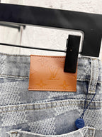 Louis Vuitton monogram jeans front pocket area with brown leather logo tab