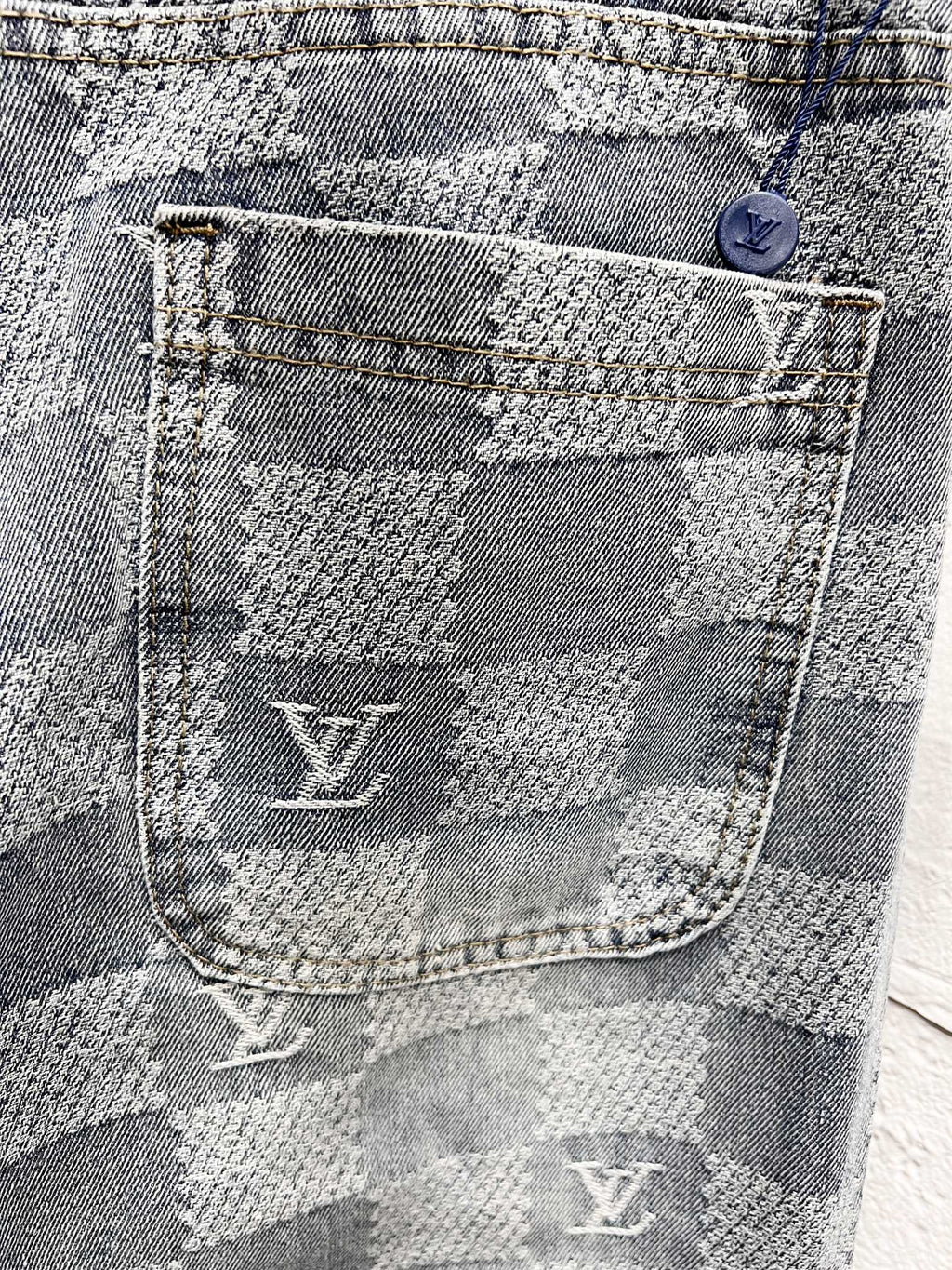 Louis Vuitton monogram jeans pocket close-up with stitched logo and checker weave
