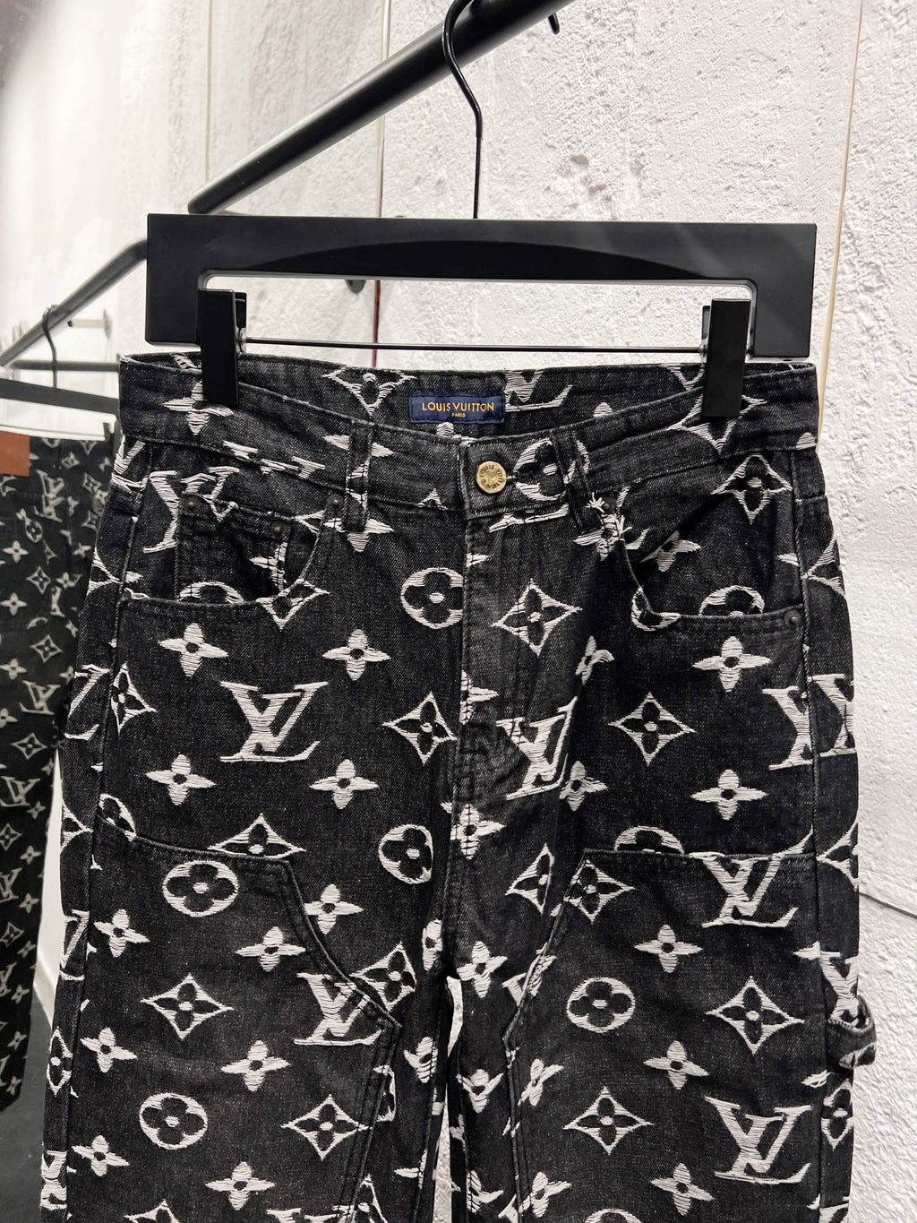 Louis Vuitton monogram print jeans front view, dark denim with white scattered logos