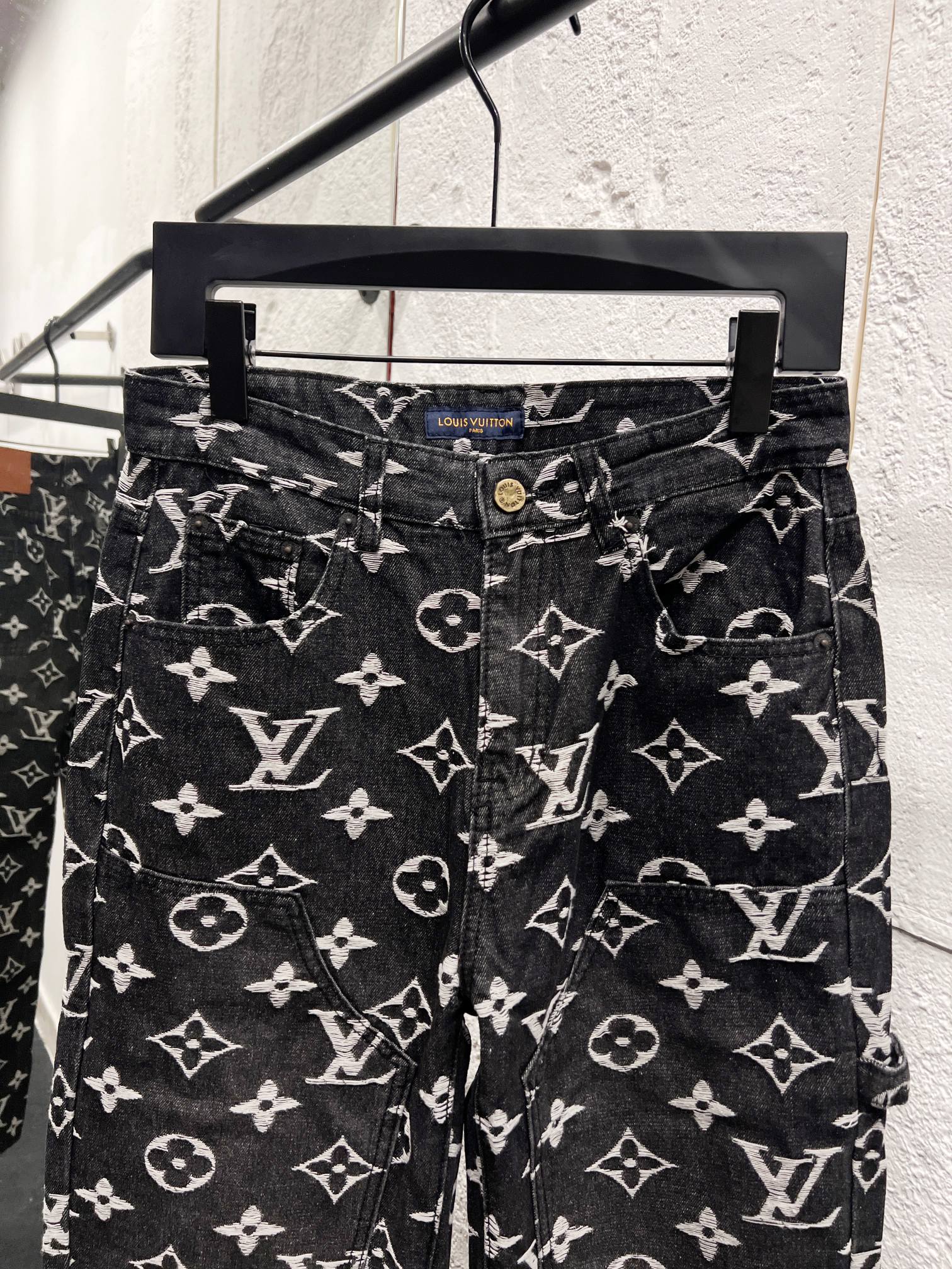 Louis Vuitton monogram print jeans front view, dark denim with white scattered logos