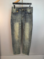 Light-wash denim pants with gold-tone button and stitched detailing, front view