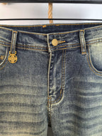 Denim waistband with gold-tone button and stitched seams, close-up