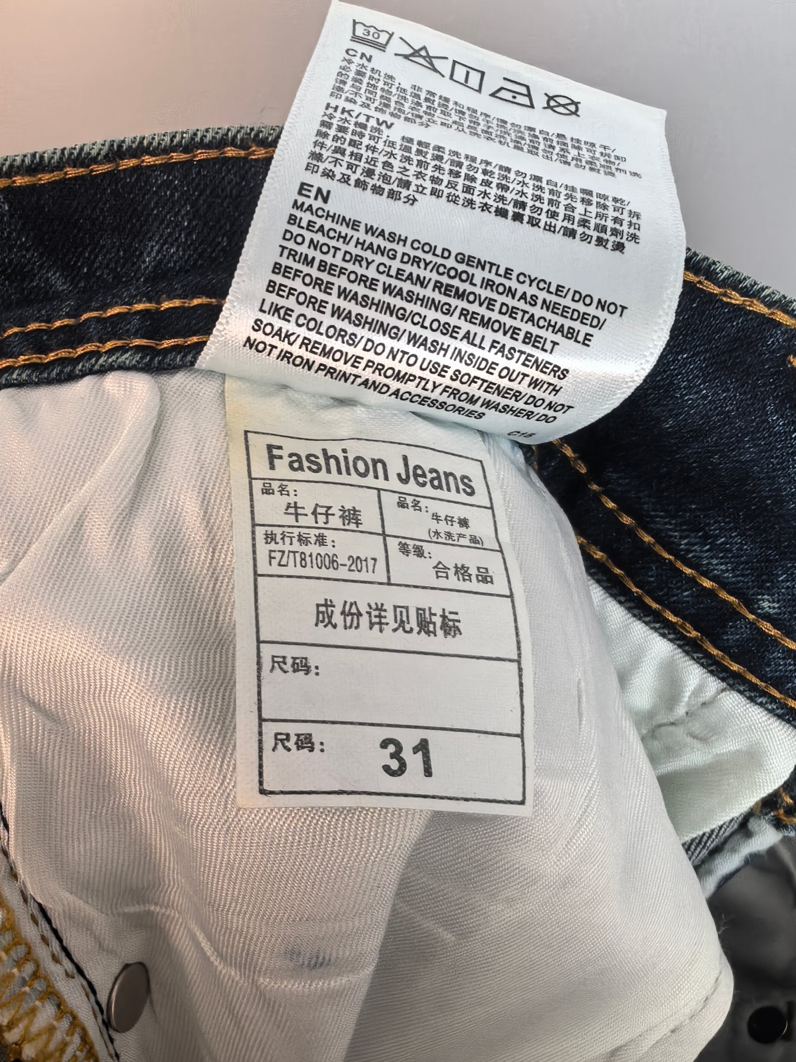White care label on denim pants with size 31, close-up