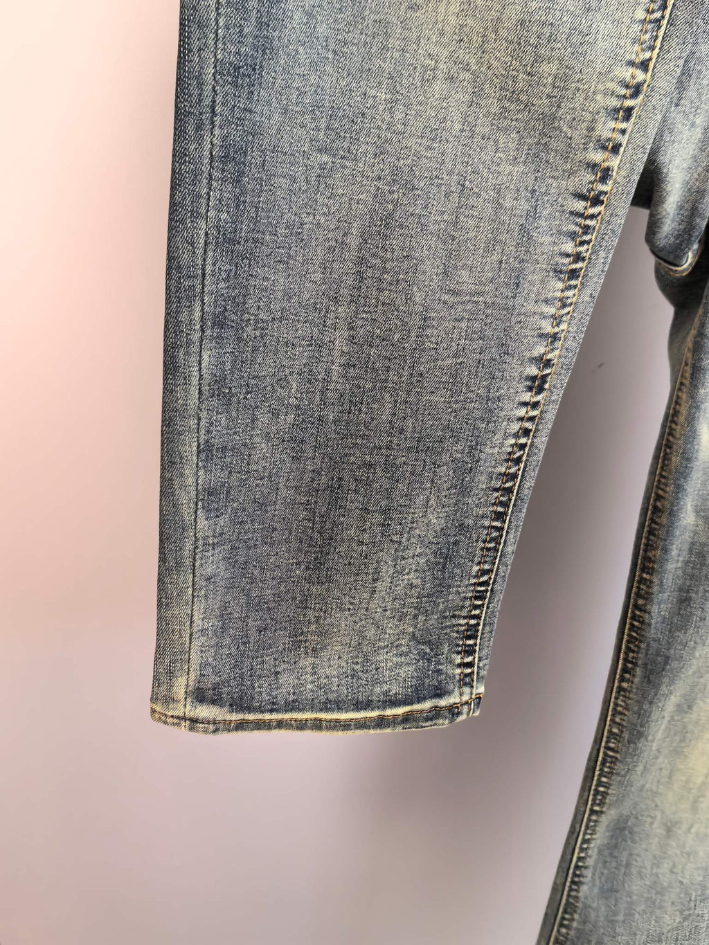 Denim pant leg hem with contrast stitching, close-up