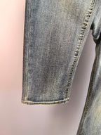 Denim pant leg hem with contrast stitching, close-up