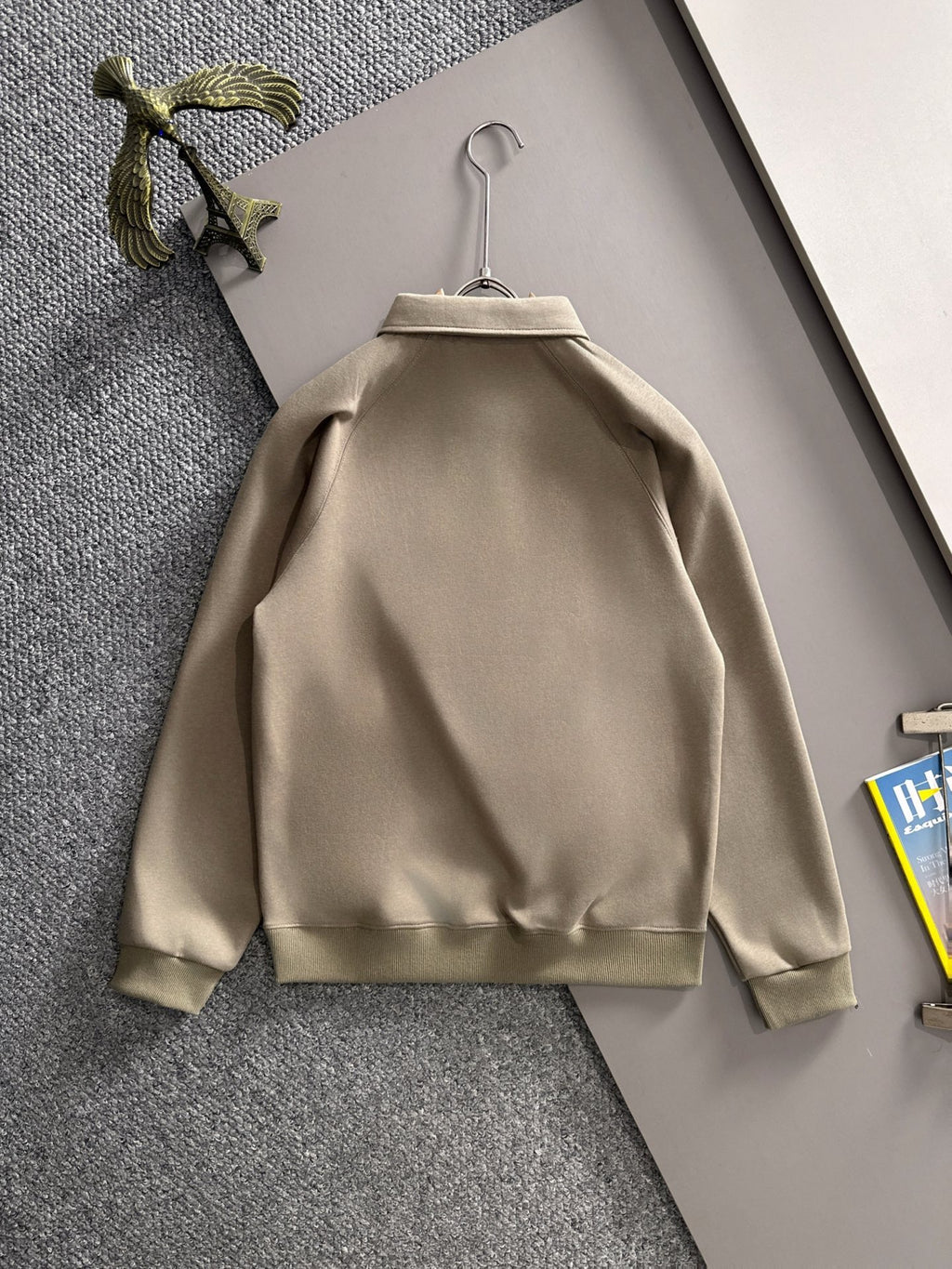 Beige long-sleeve polo back view on hanger