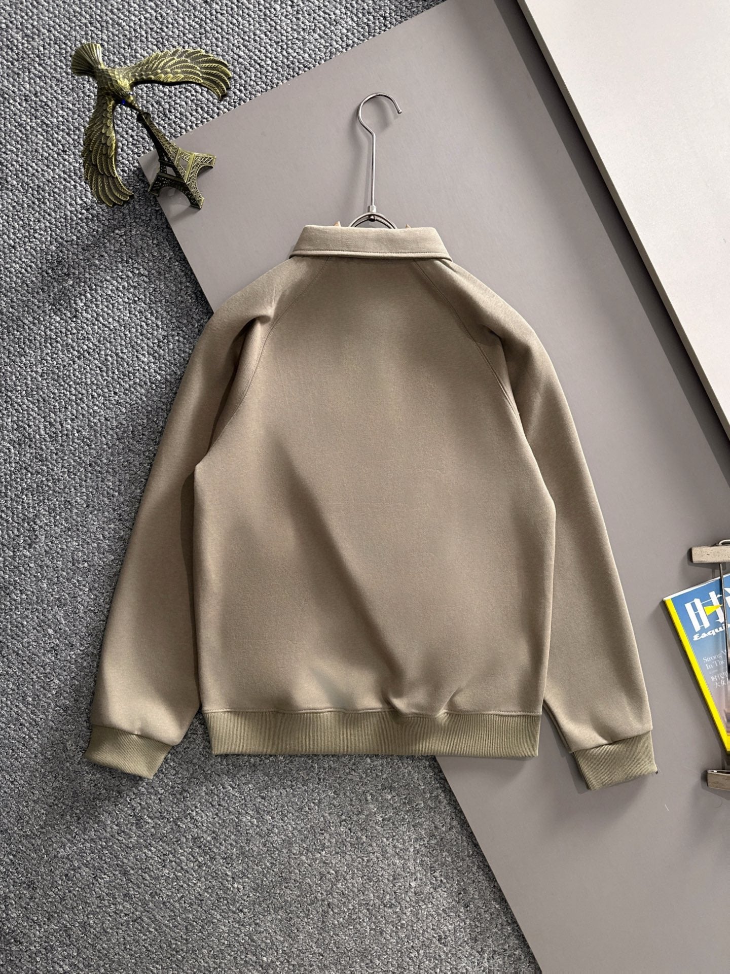 Beige long-sleeve polo back view on hanger