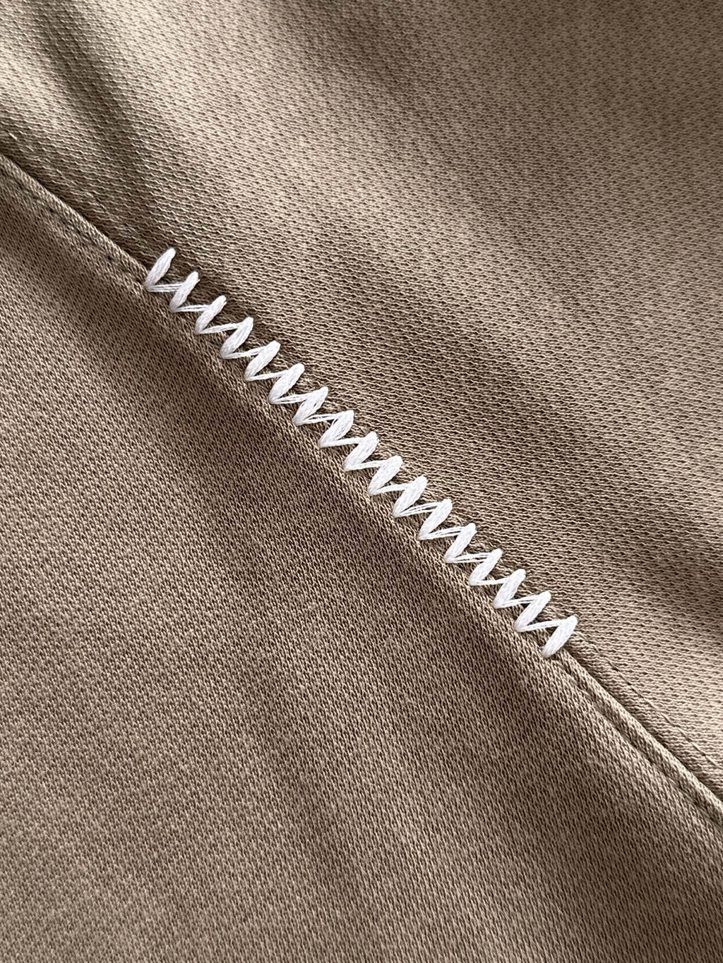 Beige long-sleeve polo with contrast zigzag stitch