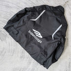 Black zip-up jacket laid flat with white Balenciaga logo and logo stripe on the back