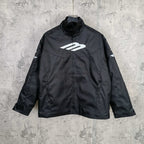 Black zip-up jacket with stand collar and white Balenciaga logo on the chest