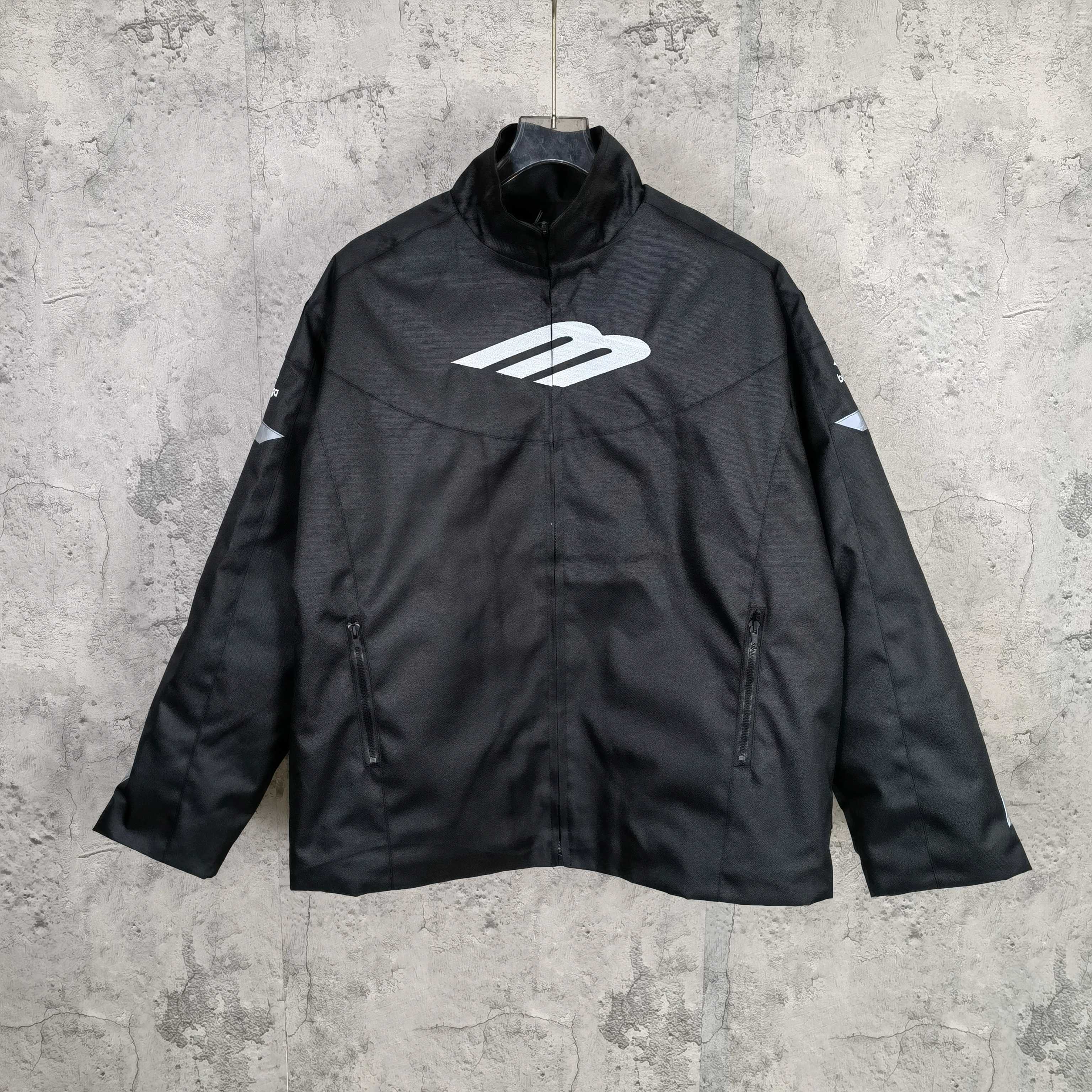 Black zip-up jacket with stand collar and white Balenciaga logo on the chest