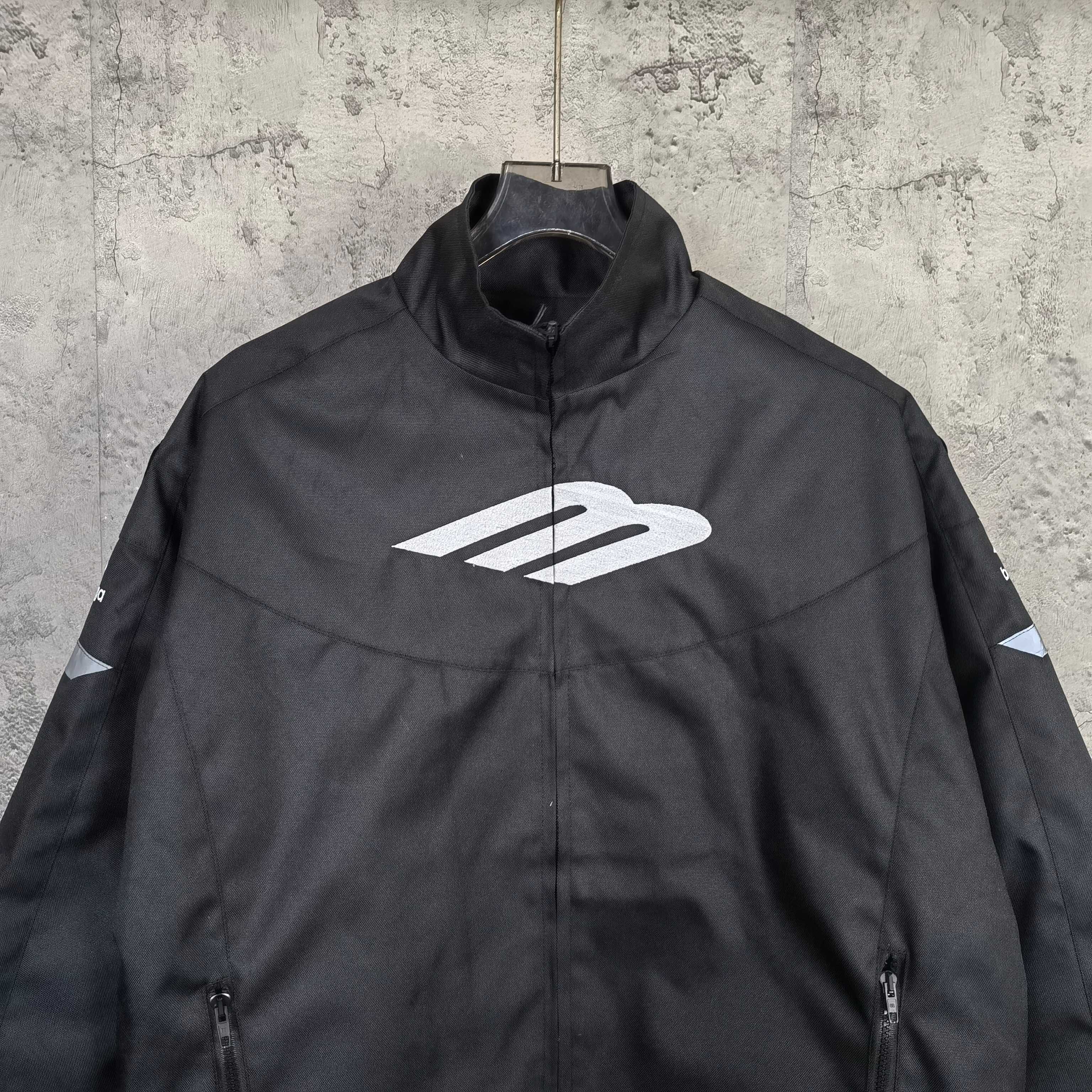 Black zip-up jacket with stand collar and large white Balenciaga logo on the chest