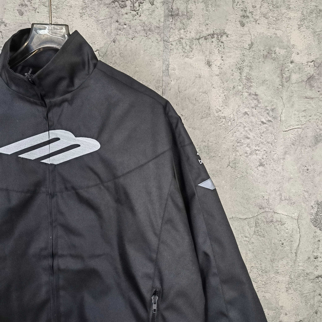 Black jacket side view with white Balenciaga emblem and front zipper detail
